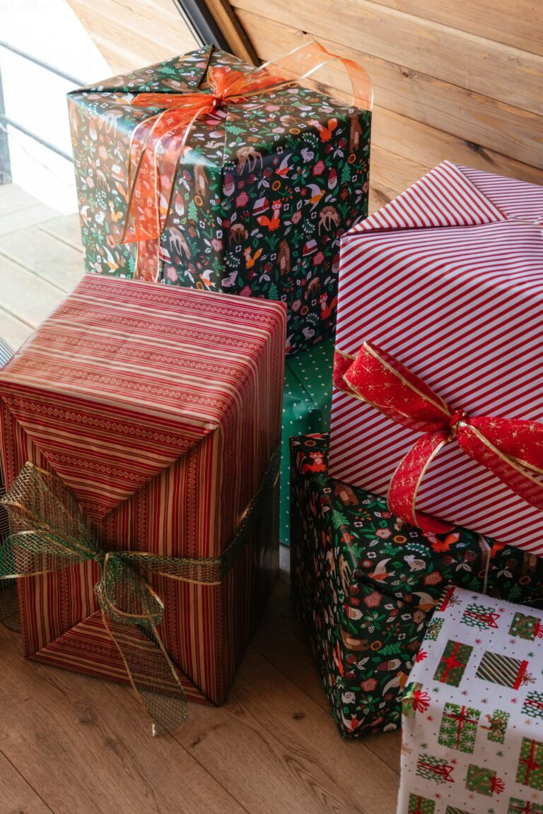 A group of wrapped gifts stacked on a wooden floor, ready to be given away.
