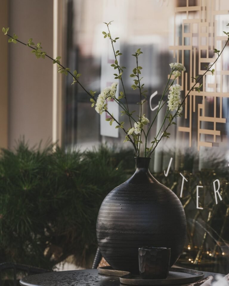 White flowering branches in soft light beside a window