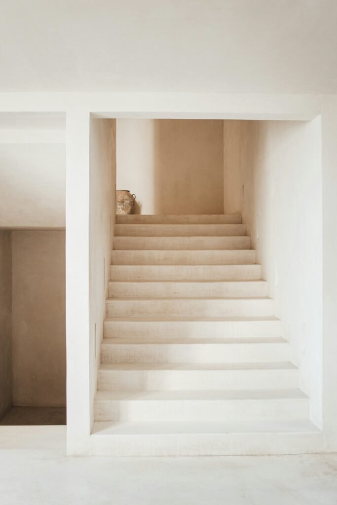 A minimalist concrete staircase rising to a landing